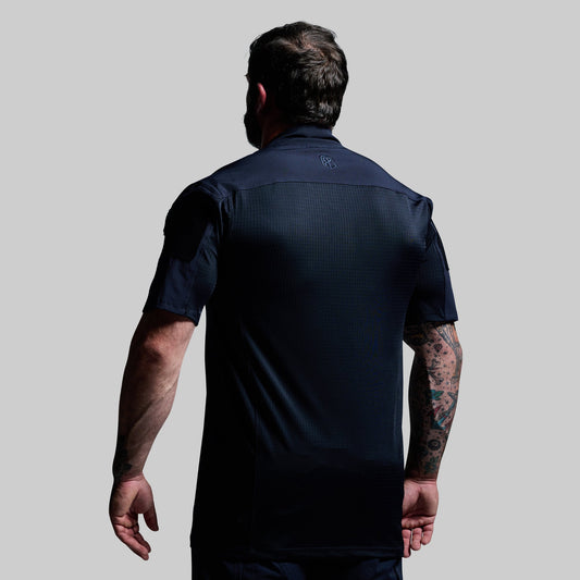 Man wearing a dark blue athletic shirt on a light gray background
