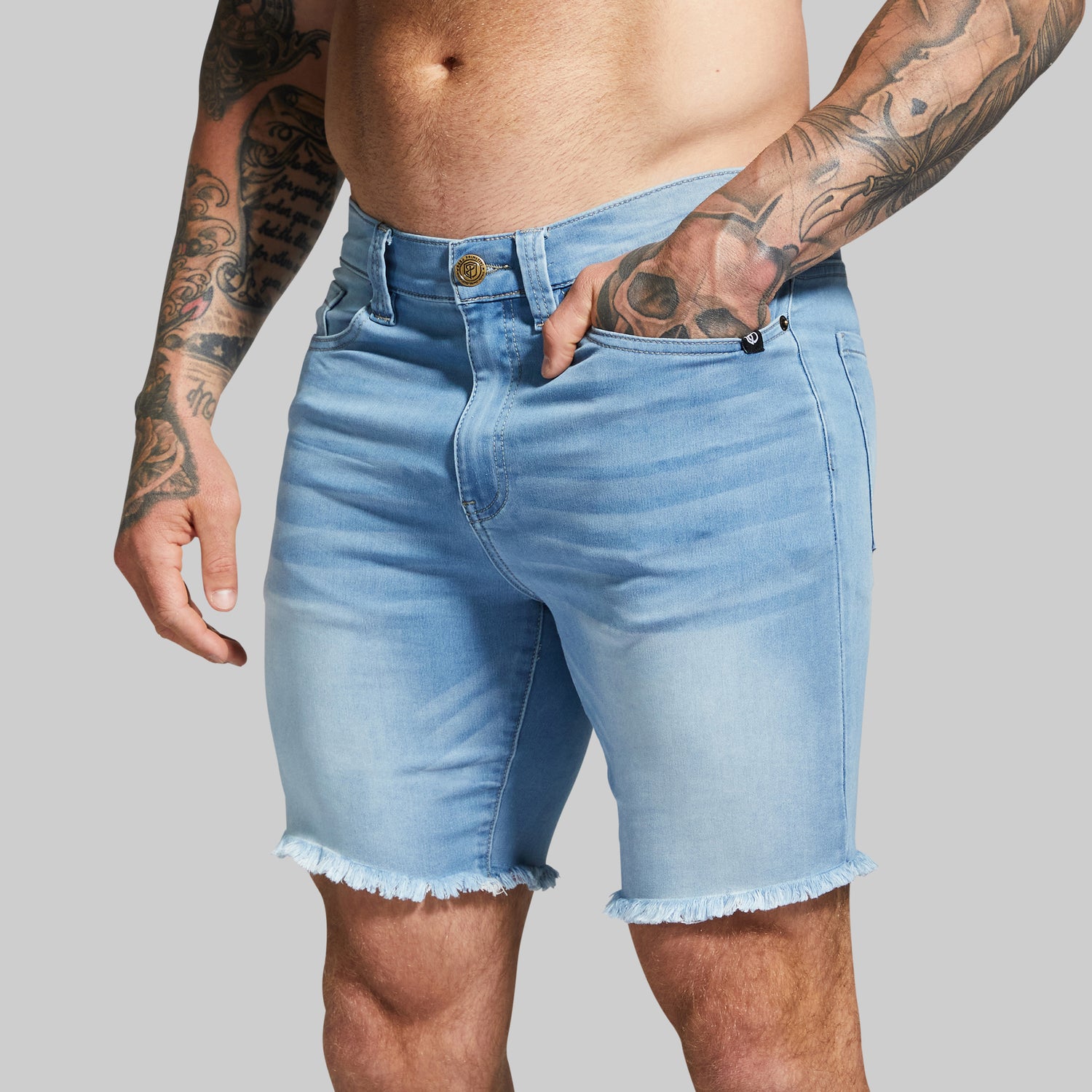 Person wearing light blue denim shorts with a gray background
