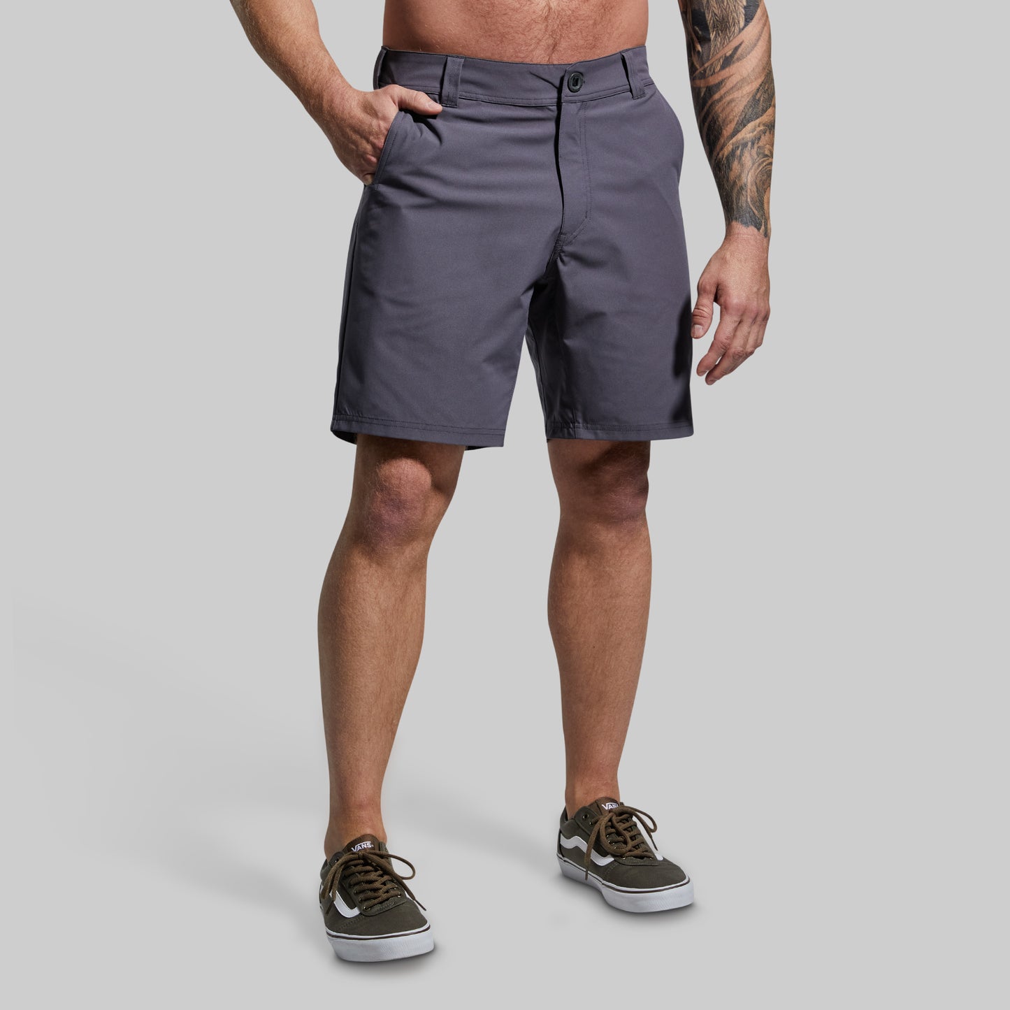 Person wearing gray shorts on a plain background