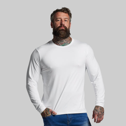 Man wearing a white long-sleeve shirt against a gray background