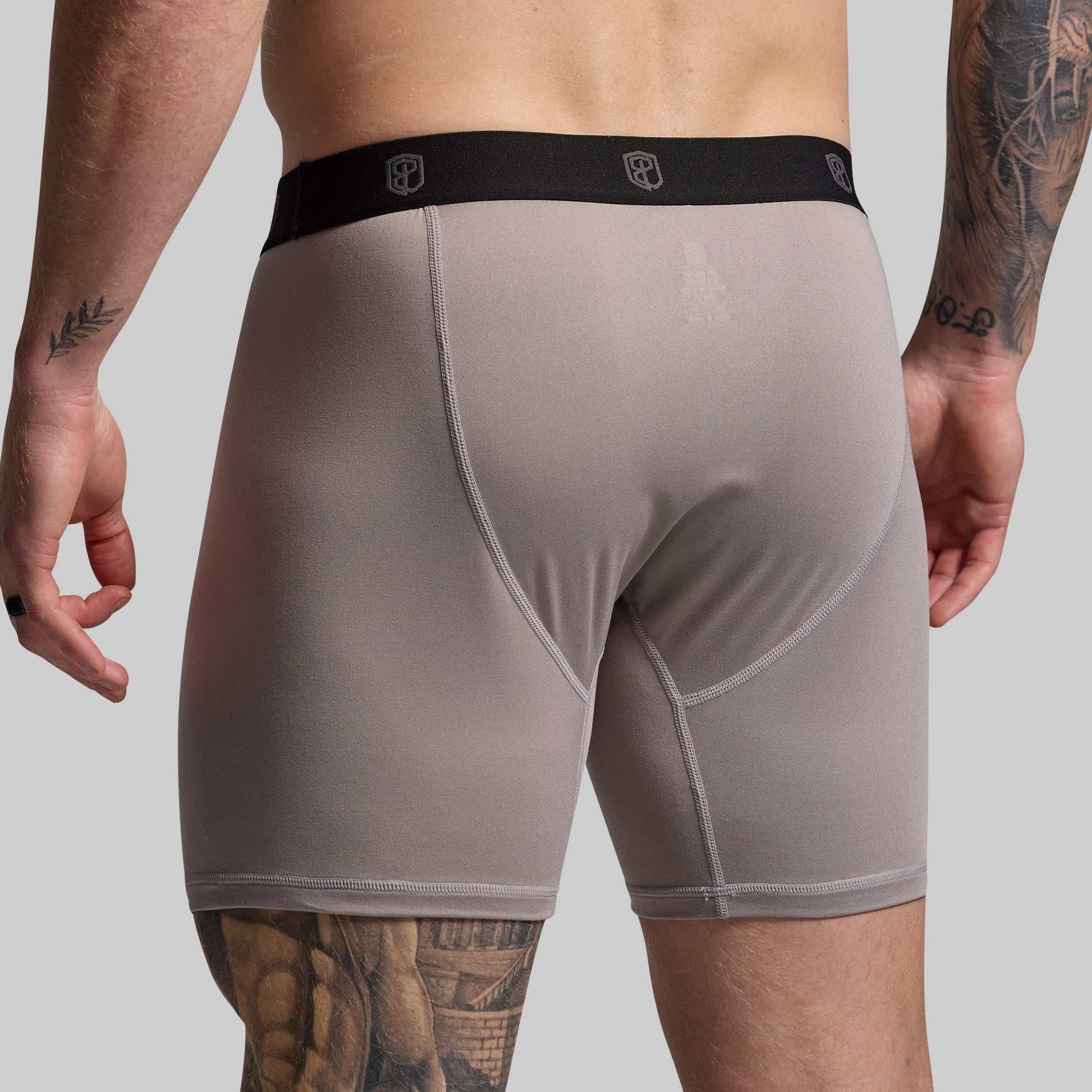 Man wearing gray boxer briefs on a plain background