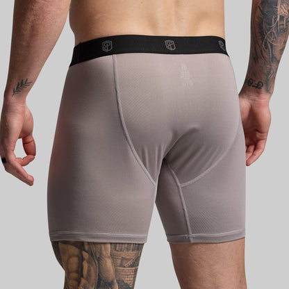 Man wearing gray boxer briefs on a plain background