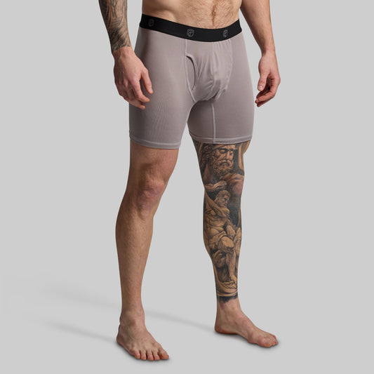 Man wearing gray boxer briefs on a plain background
