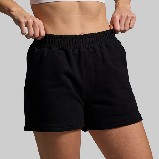 Person wearing black shorts on a gray background