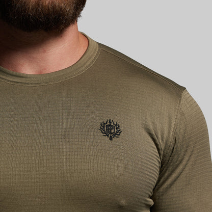 Olive green long-sleeve shirt with a logo on the chest against a neutral background