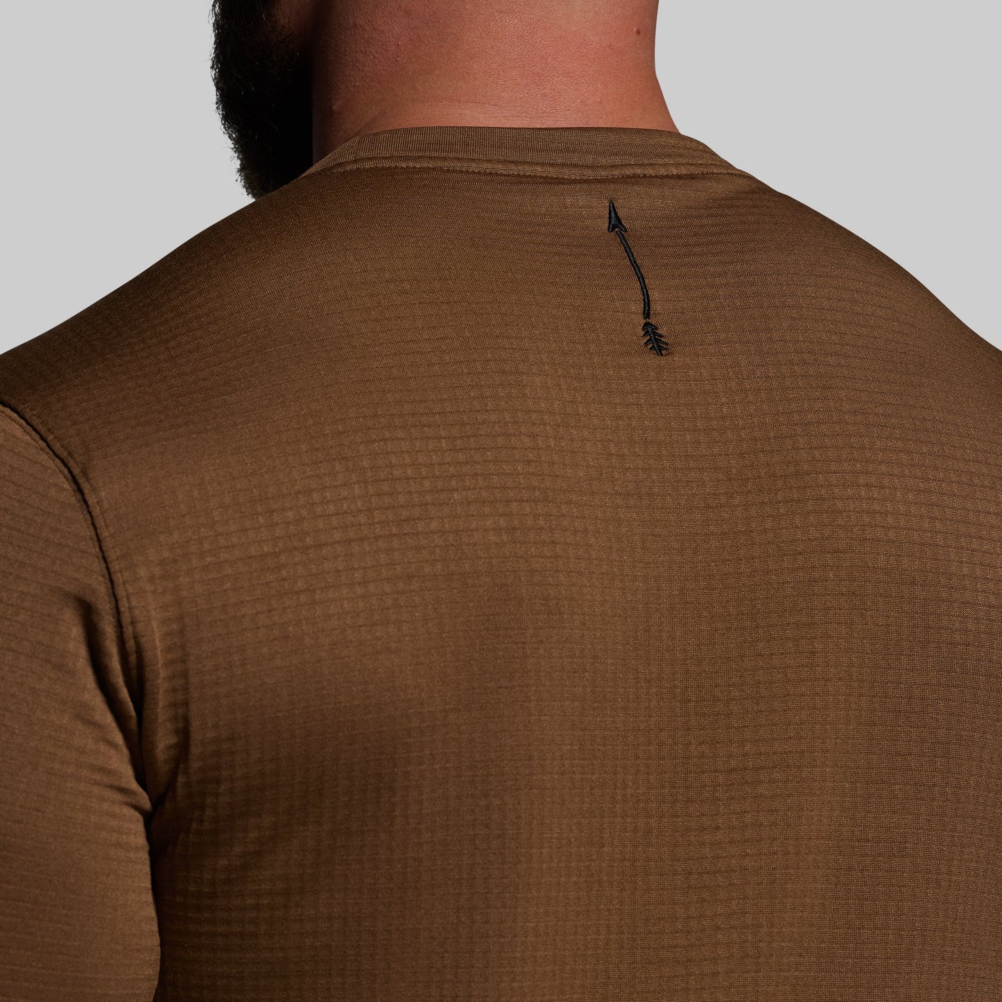 Brown textured shirt worn by a person on a light gray background