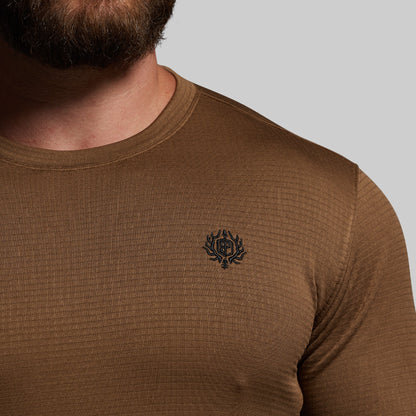 Brown long-sleeve shirt with a small logo on a gray background