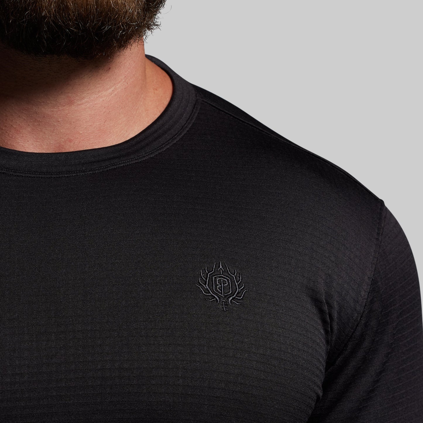 Black long-sleeve shirt with a logo on a gray background