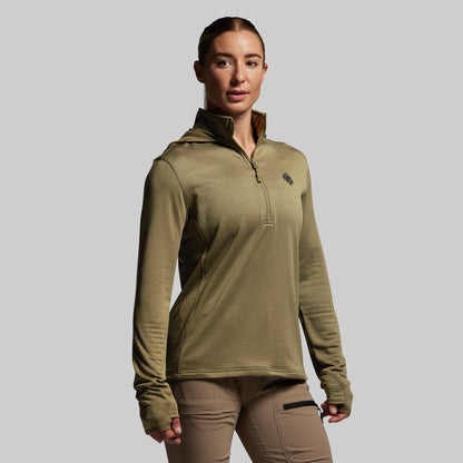 Person wearing a green pullover with a logo on a gray background