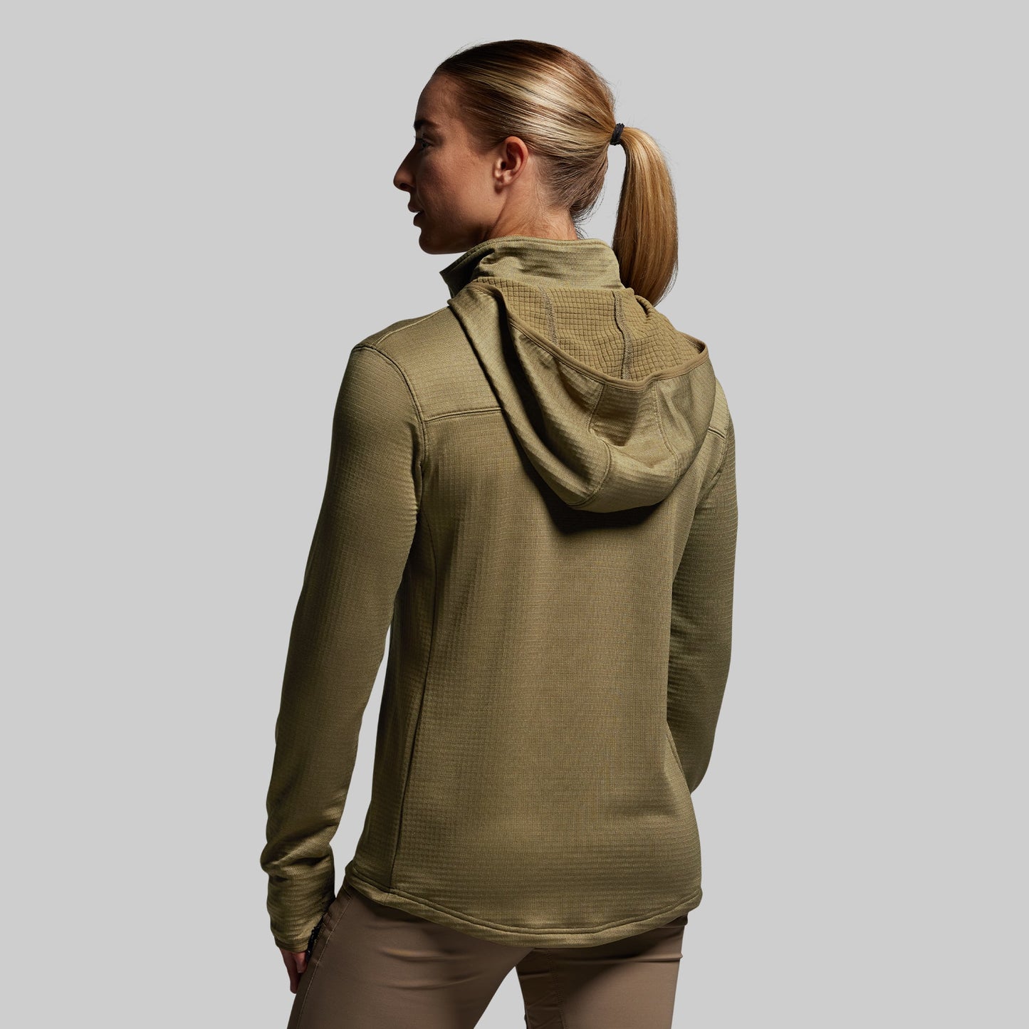 Person wearing a green hoodie on a plain background