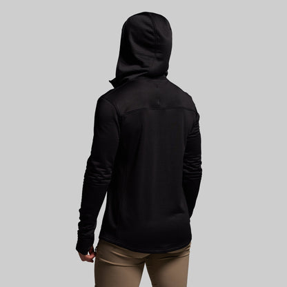 Person wearing a black hoodie from behind on a gray background