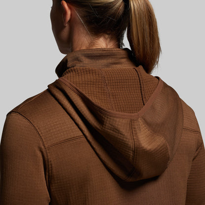 Person wearing a brown textured hoodie on a plain background