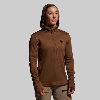 Person wearing a brown hoodie with a small logo on a gray background