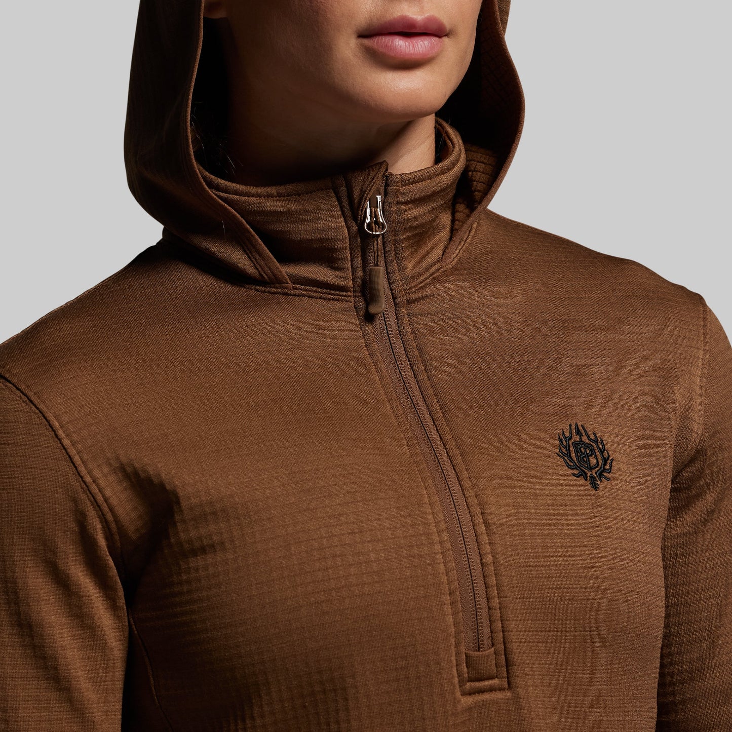 Brown hooded jacket with a small logo on a plain background