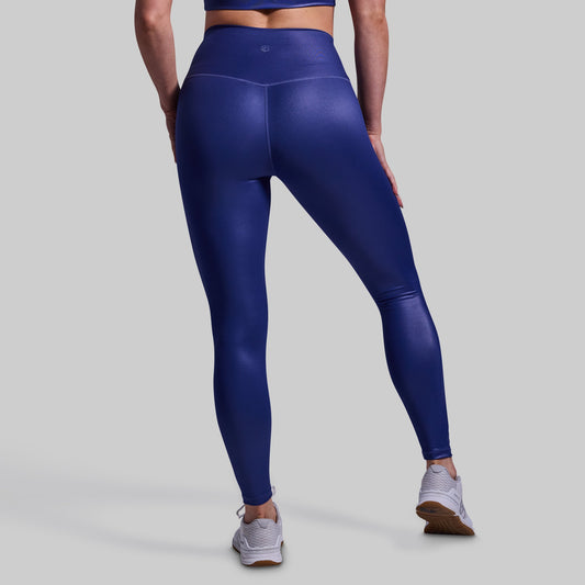 Person wearing blue leggings on a gray background
