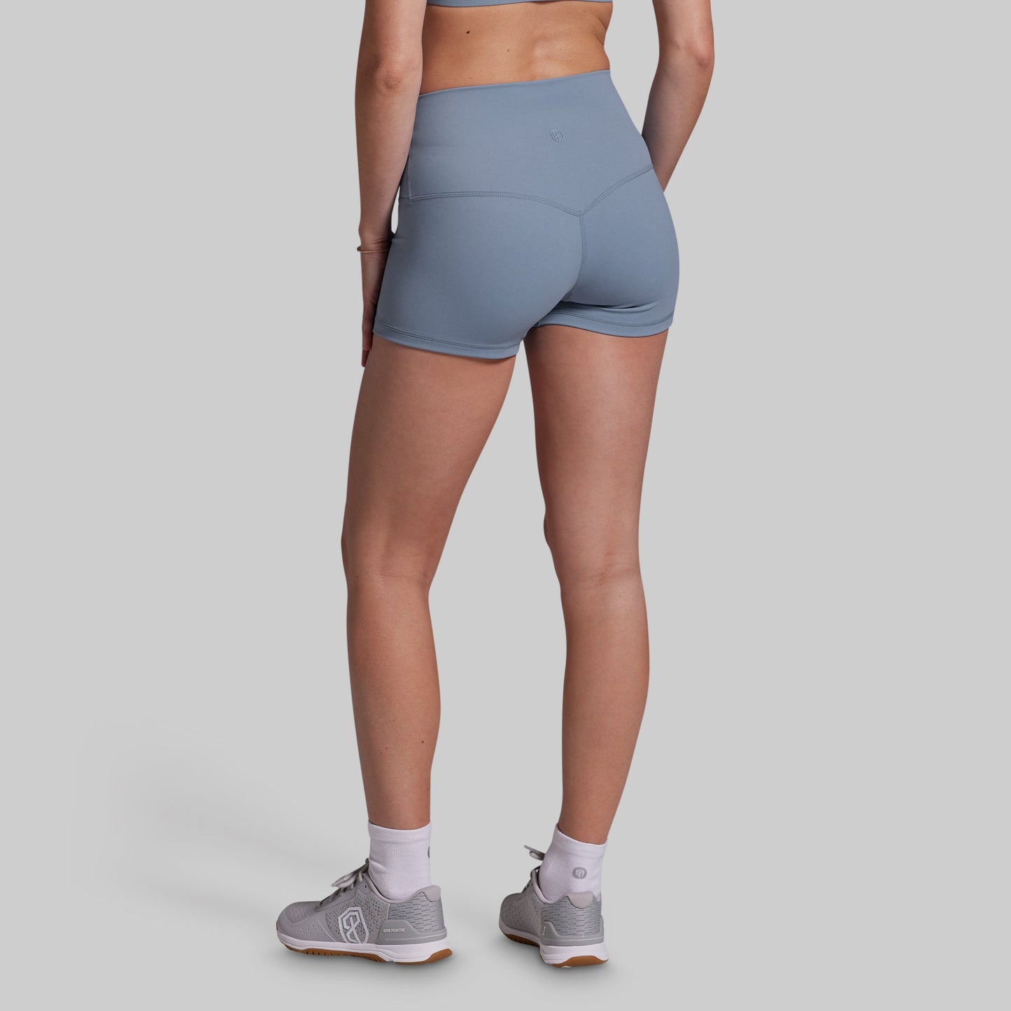Person wearing gray athletic shorts on a plain background