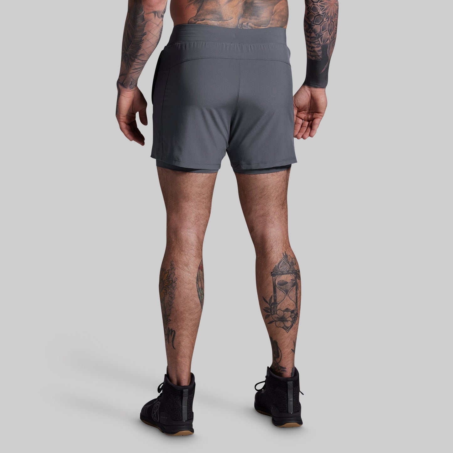 Person wearing gray athletic shorts on a light gray background
