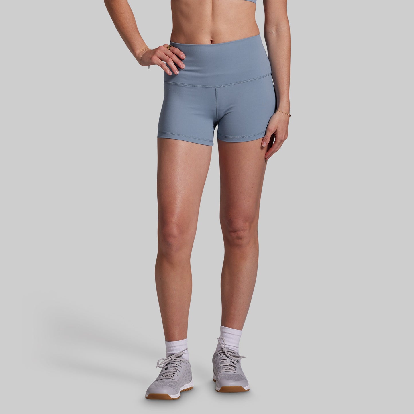 Person wearing light blue athletic shorts on a gray background