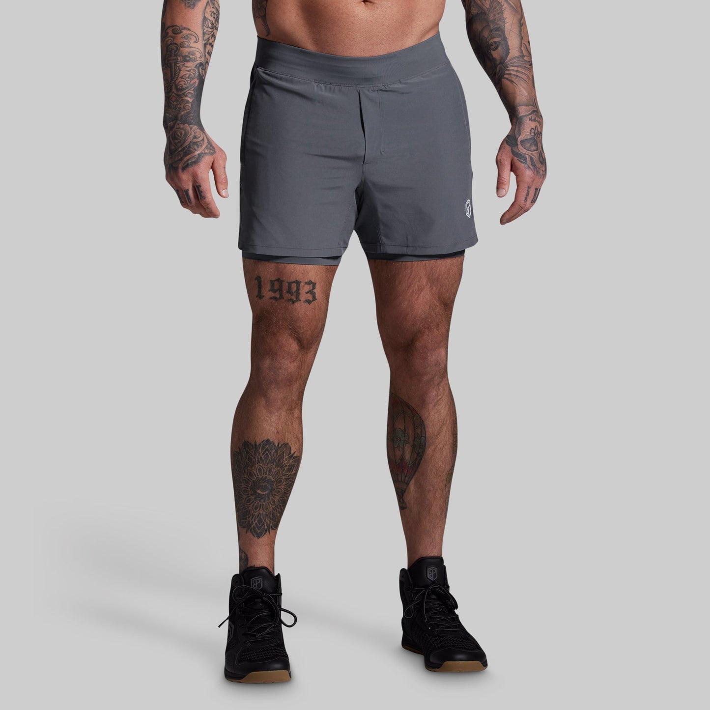 Person wearing gray athletic shorts on a plain background