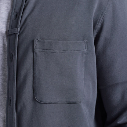 Close-up of a dark gray long-sleeve button-up shirt with a chest pocket, worn over a light gray undershirt.