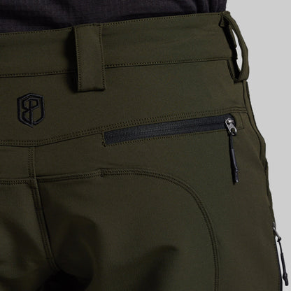 Close-up of olive green outdoor pants showing a zippered pocket, belt loop, and a black embroidered logo on the back.