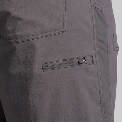 Close-up of gray shorts with a zipper pocket on a plain background
