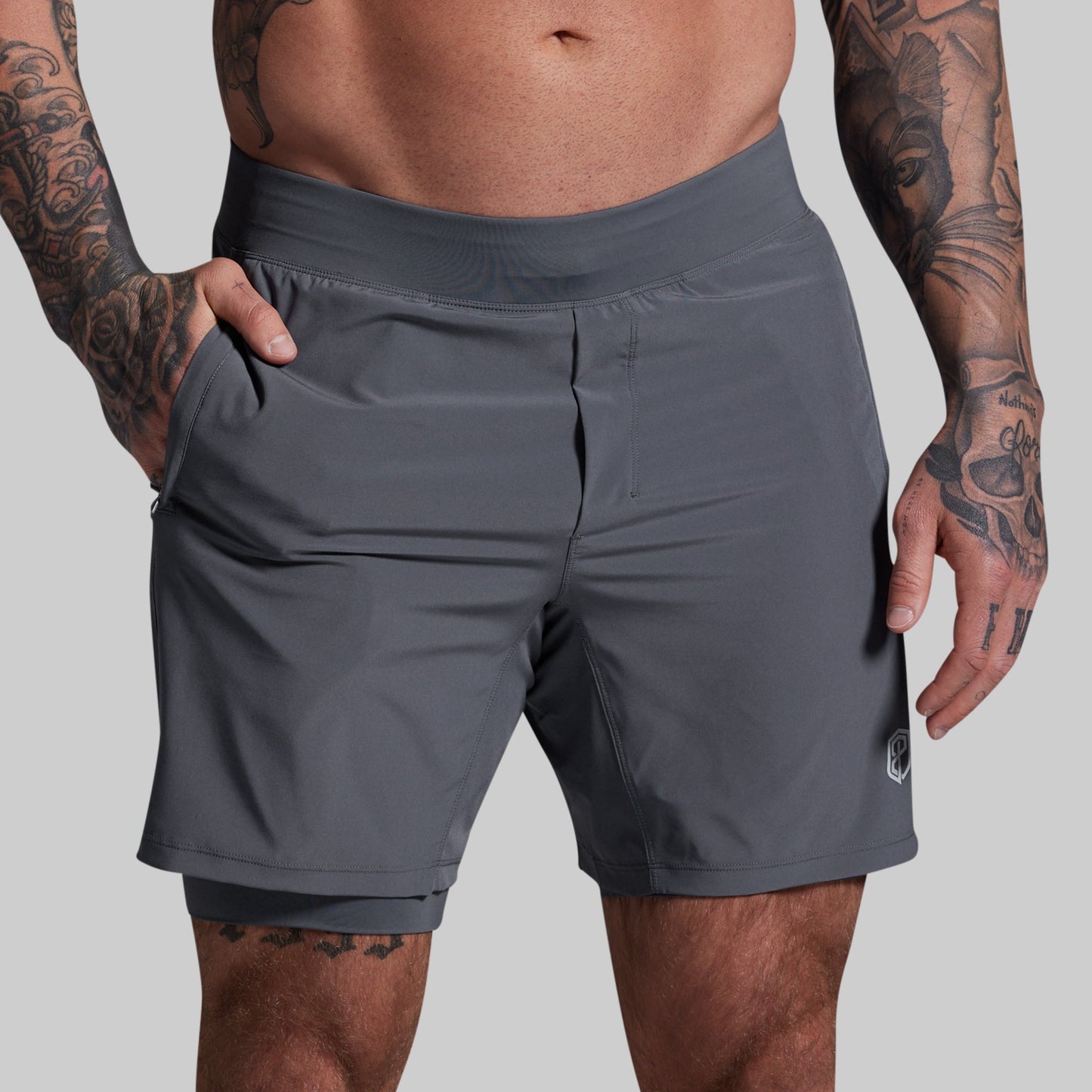 Person wearing gray athletic shorts on a plain background
