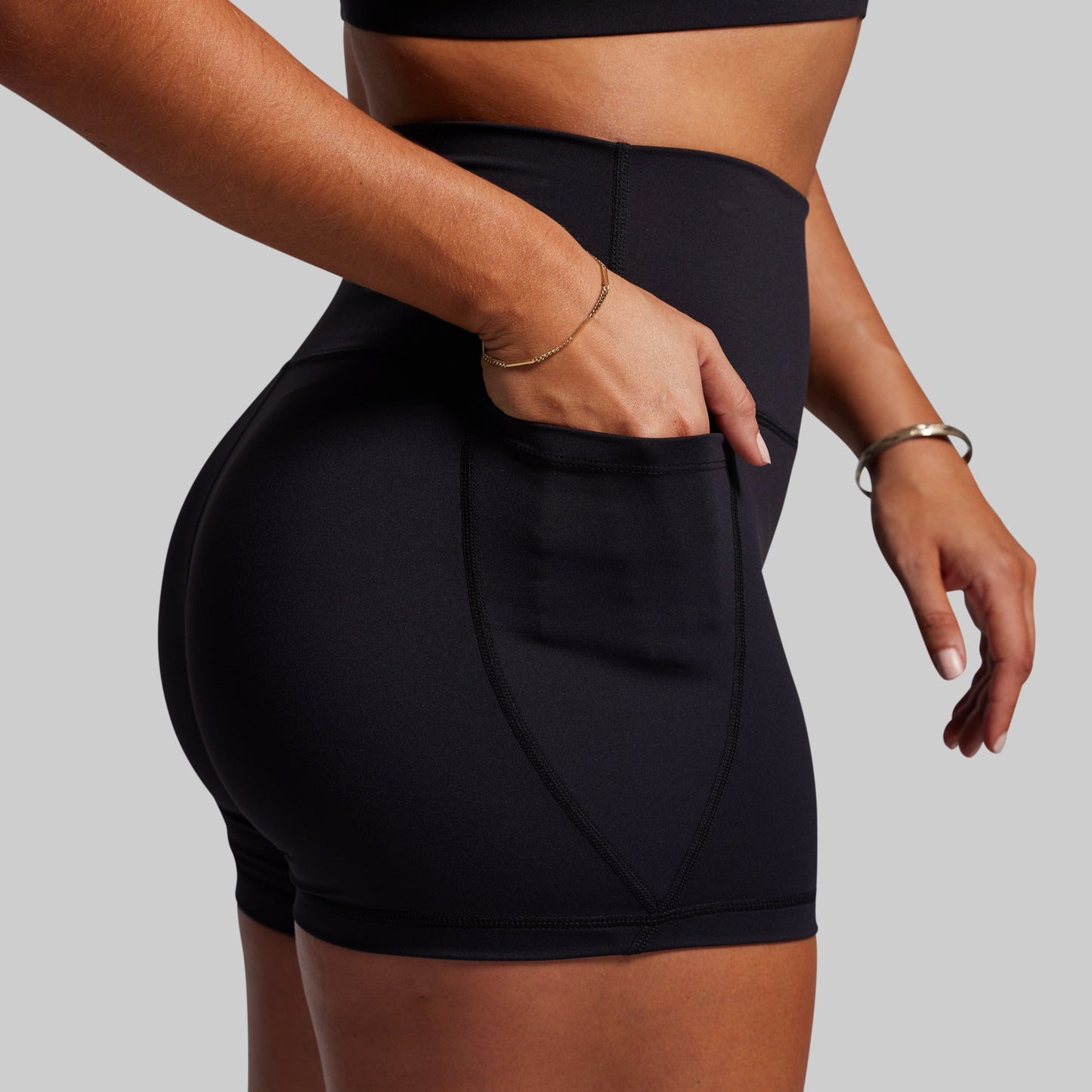 Person wearing black athletic shorts on a gray background