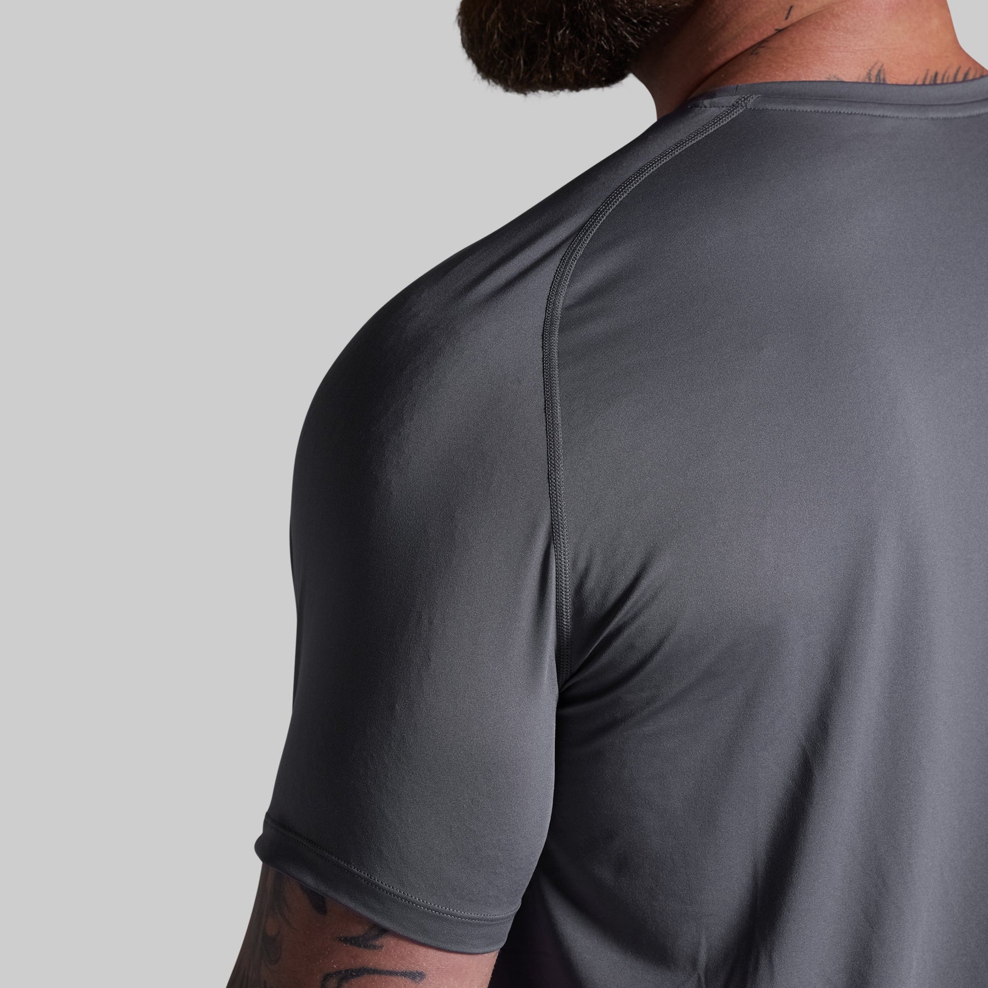 Gray athletic shirt worn by a person on a gray background