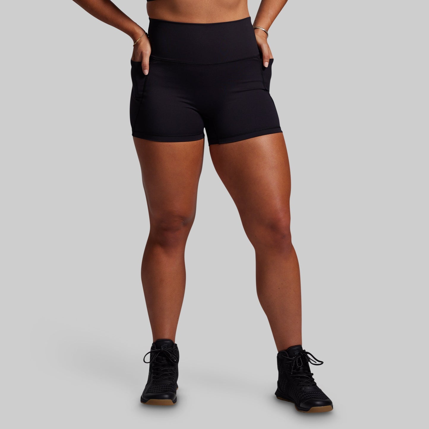 Person wearing black athletic shorts on a gray background