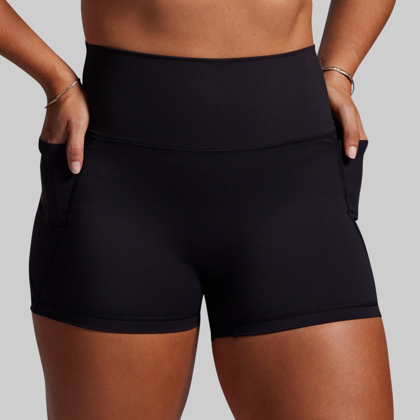 Black athletic shorts worn by a person on a gray background