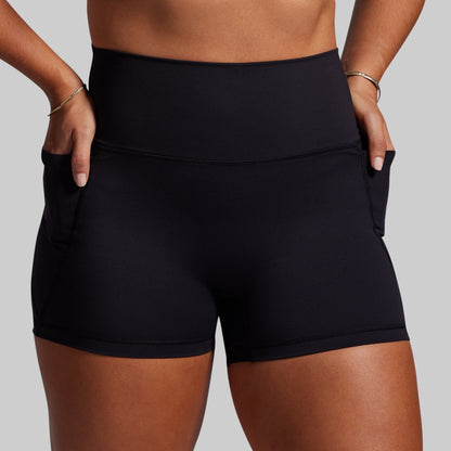 Black athletic shorts worn by a person on a gray background
