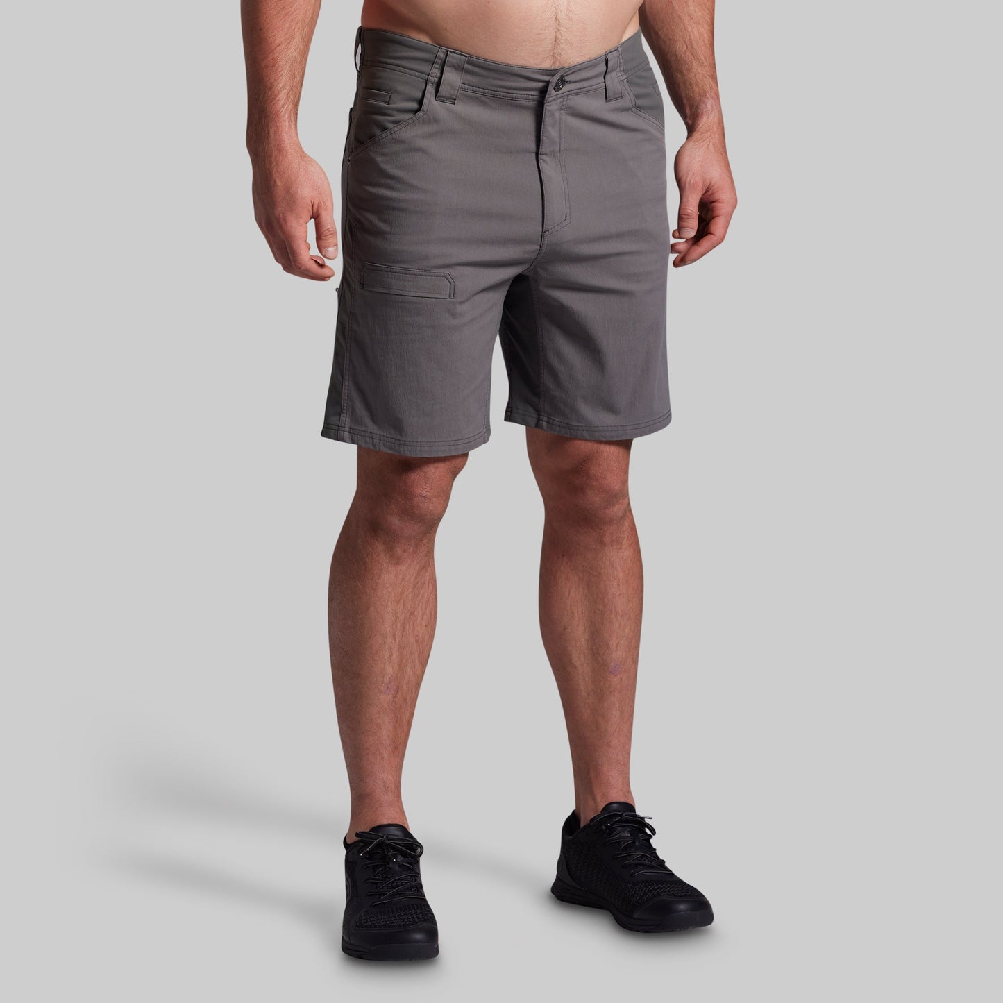 Person wearing gray shorts on a plain background