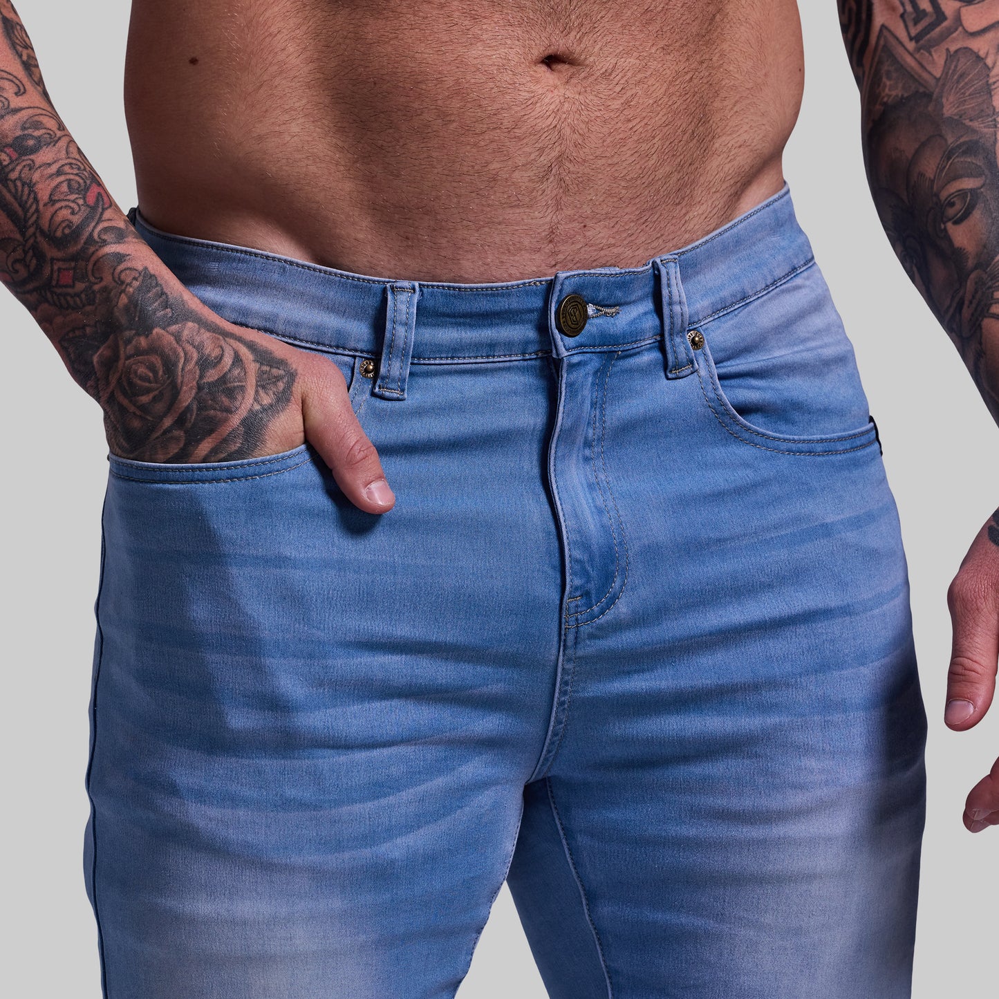 Person wearing blue jeans with a plain background
