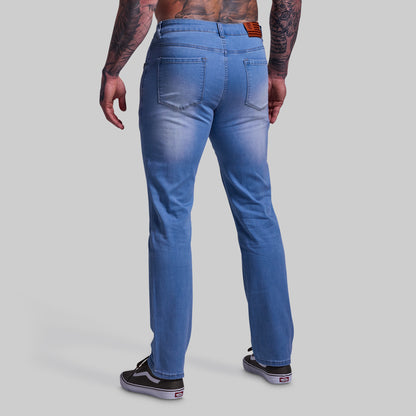 Person wearing blue jeans on a gray background