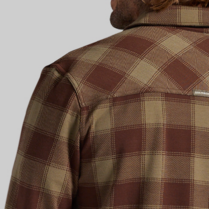 Close-up of a man shown from the back wearing a brown and tan plaid flannel shirt.