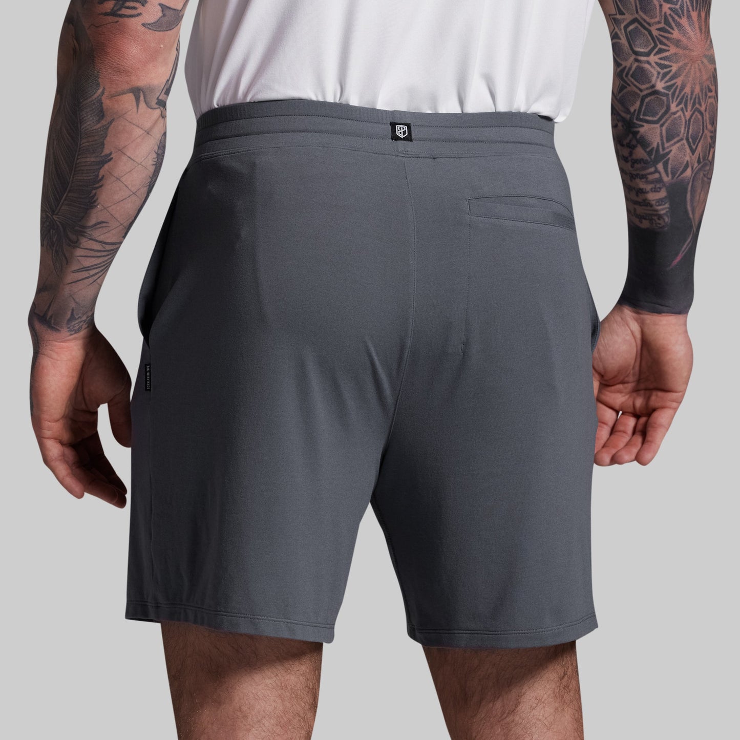 Person wearing gray shorts on a plain background