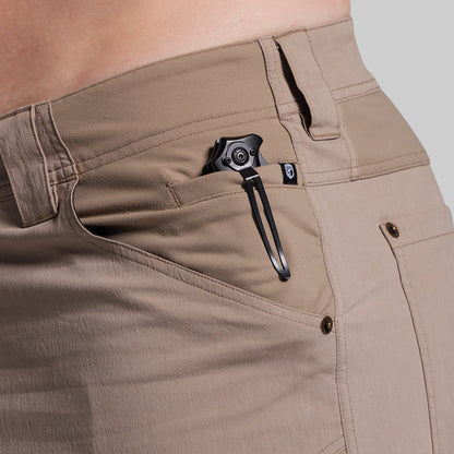 Close-up of beige shorts with a black pocket knife on a neutral background