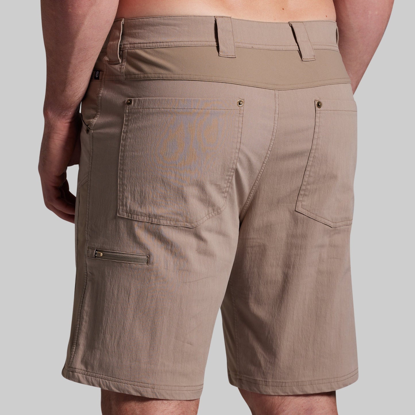 Beige shorts worn by a person on a plain background