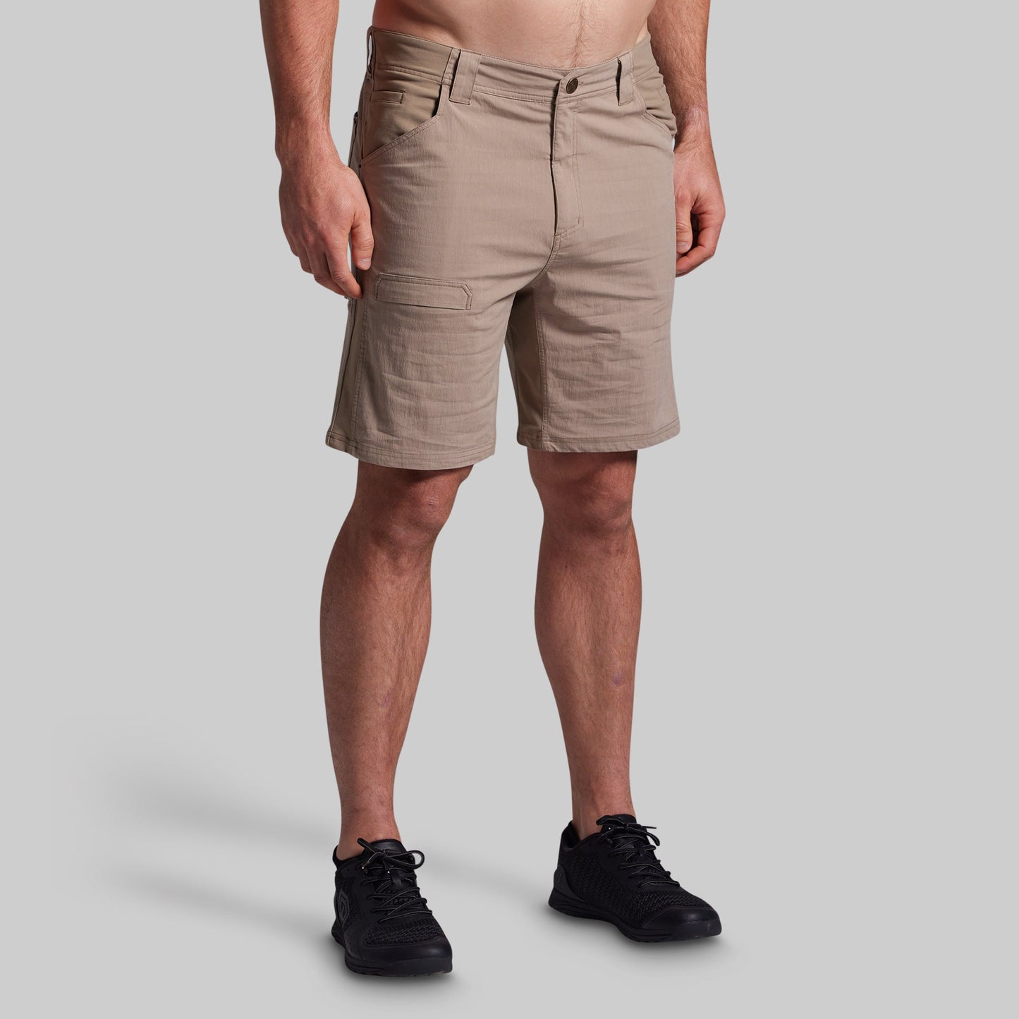 Beige shorts worn by a person on a gray background