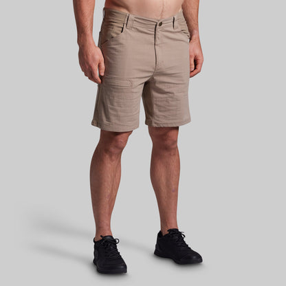 Beige shorts worn by a person on a gray background