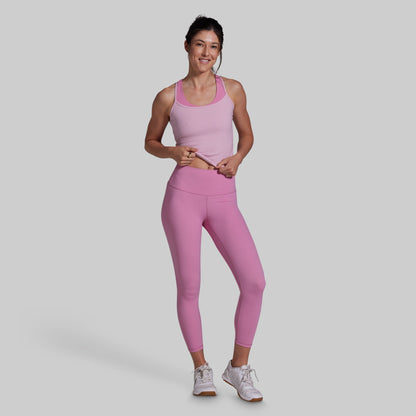 Woman wearing a pink athletic outfit on a gray background