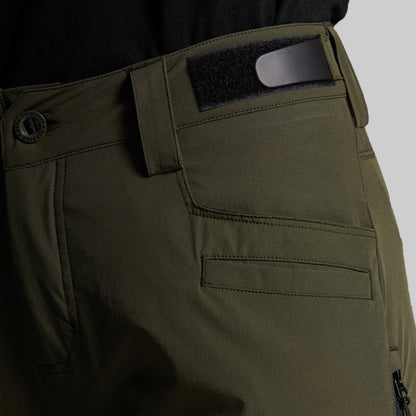 Close-up of olive green outdoor pants showing the waistband, belt loop with a black insert, button closure, and front pocket stitching.