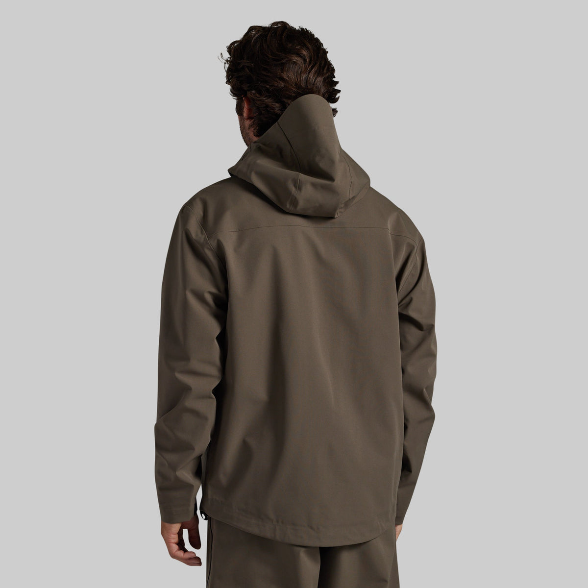 Man wearing the Ranger Green Mission FLEX Rain Jacket 2.0, back view
