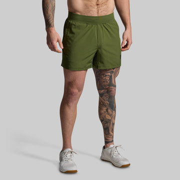 Person wearing green shorts on a plain background