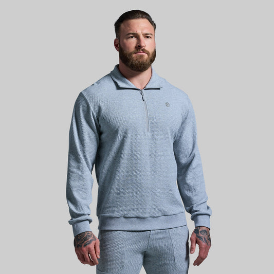 A male model wearing a paloma grey Recharge Cloud Sweatshirt with a ¼ zip front and mock turtle neck.