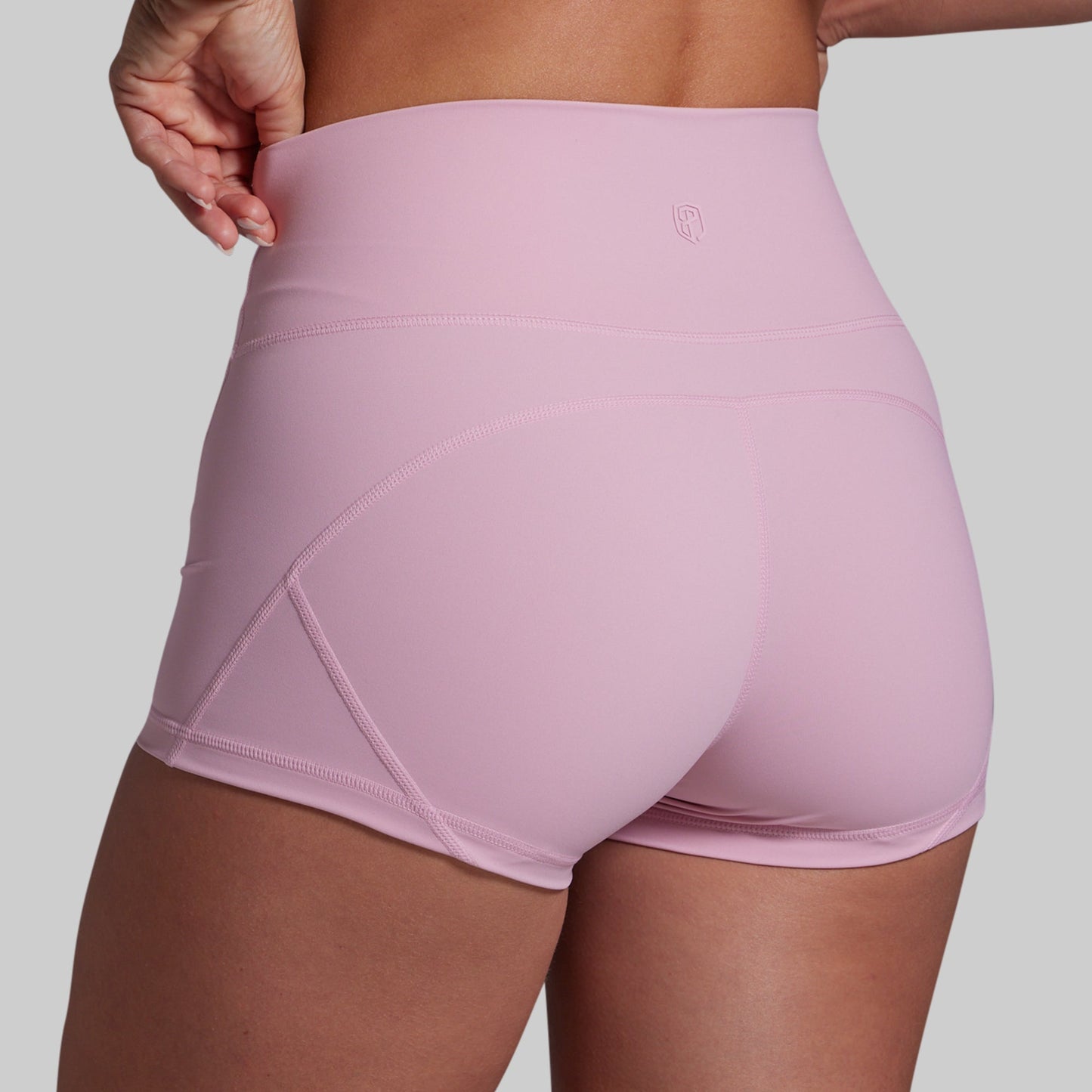 Pink athletic shorts worn by a person on a plain background