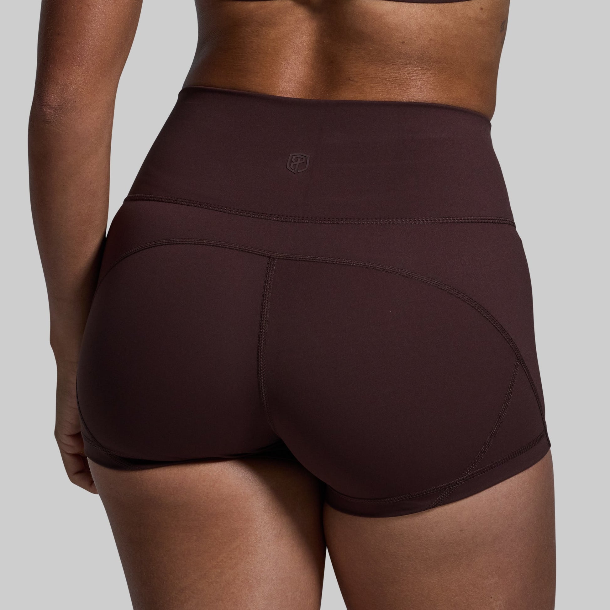 Brown athletic shorts worn by a person on a gray background