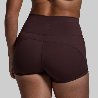 Brown athletic shorts worn by a person on a gray background
