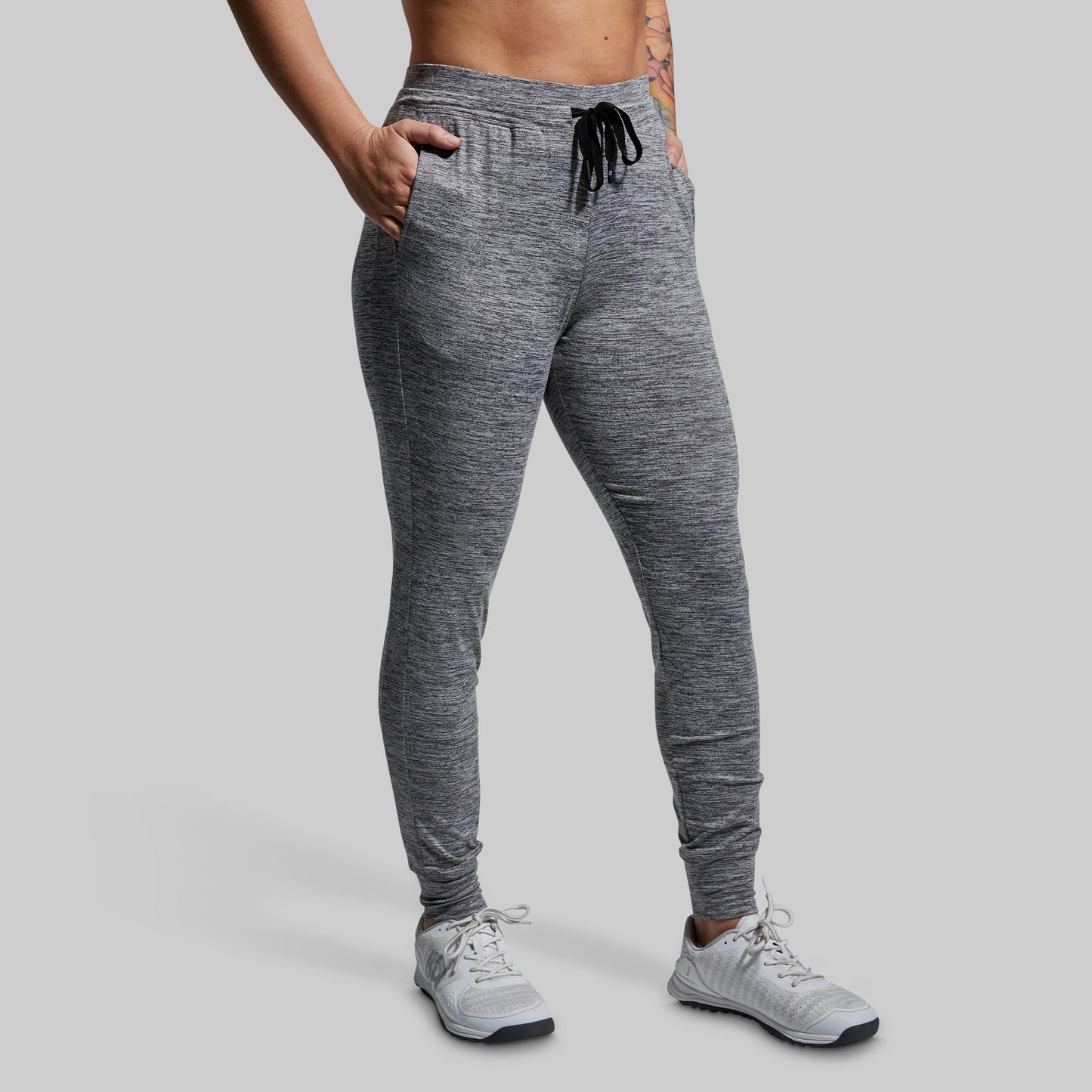 Person wearing gray jogger pants on a plain background